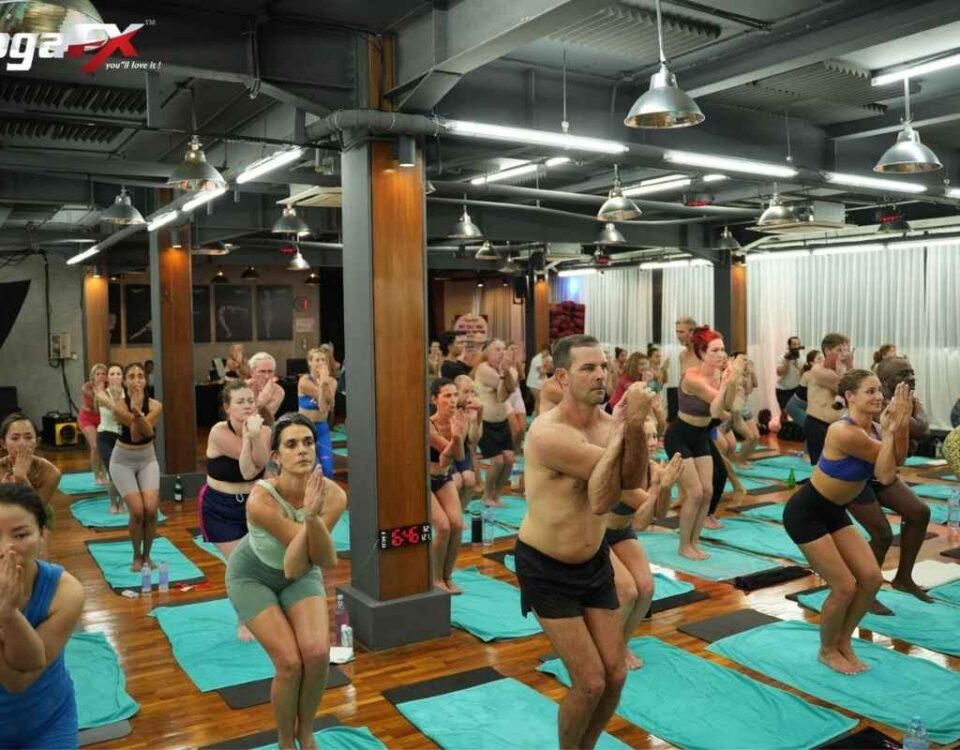 Yoga student practising a hot yoga posture during Bikram-style teacher training in a heated studio