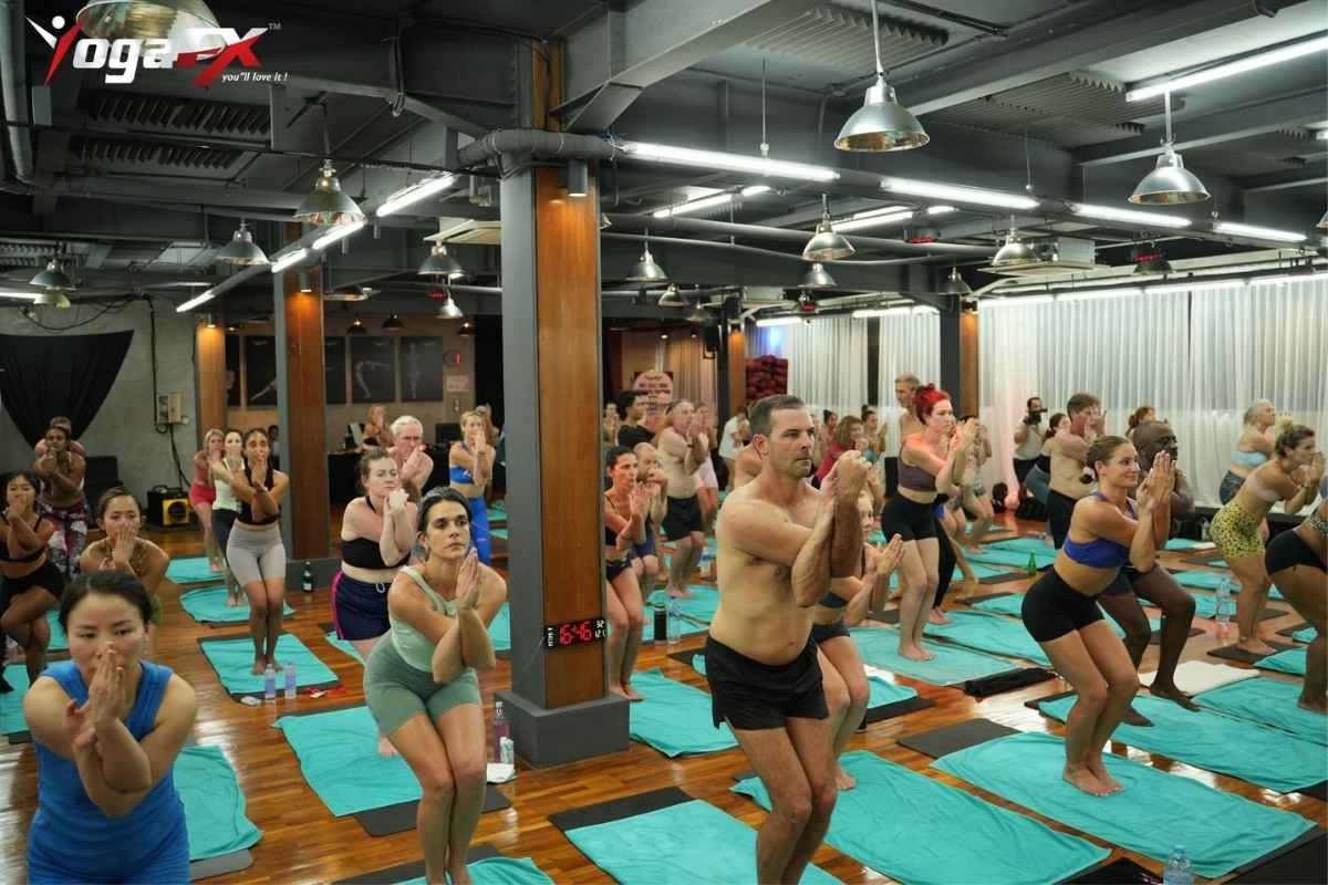 Yoga student practising a hot yoga posture during Bikram-style teacher training in a heated studio