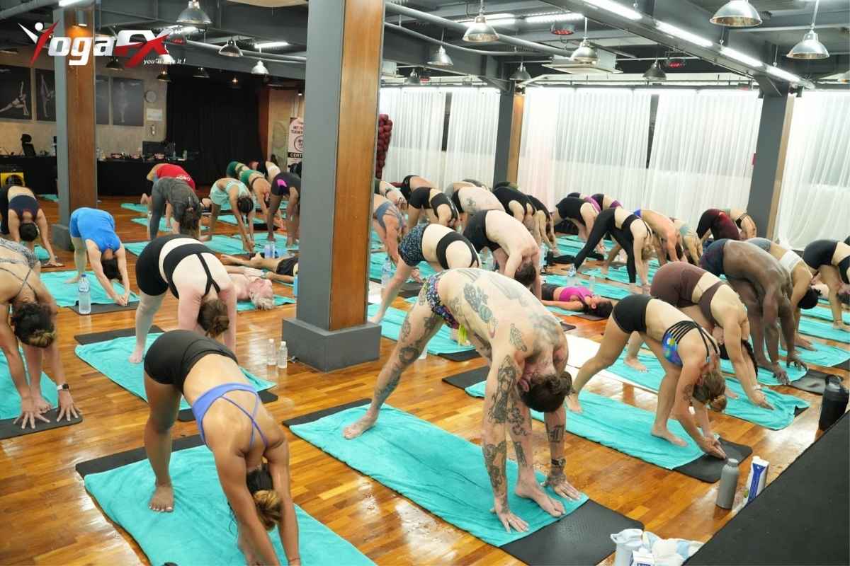 Student speaking with a yoga instructor before class in a heated studio