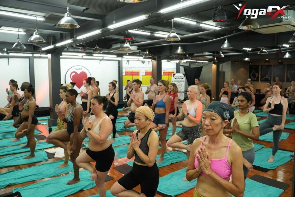 Students practicing Bikram Hot 26 and 2 postures during a yoga teacher training session.