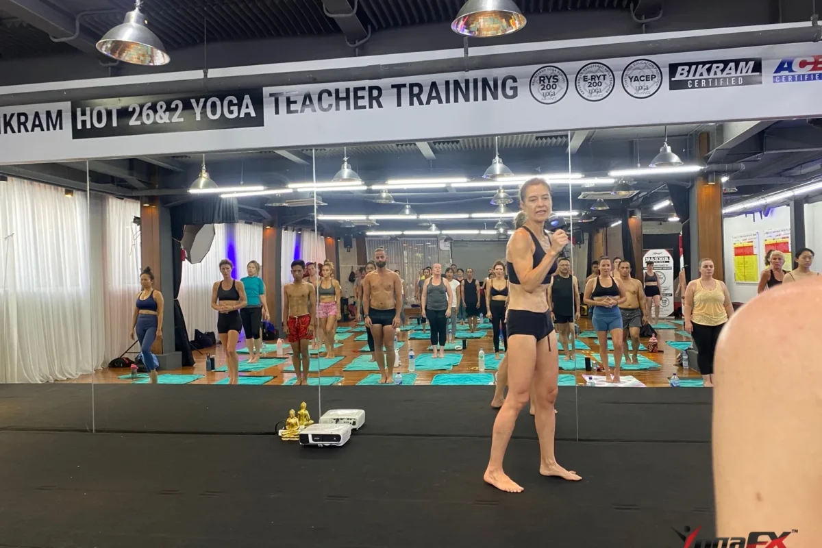 How many men do yoga: men and women standing side by side in a mixed hot yoga class as the teacher speaks