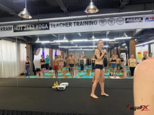 How many men do yoga: men and women standing side by side in a mixed hot yoga class as the teacher speaks