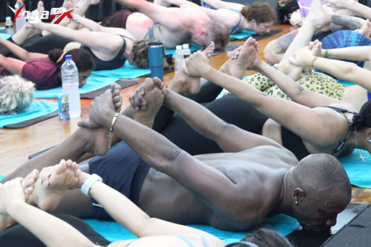 Students of mixed ages lying in the floor series of a heated class with their legs raised together