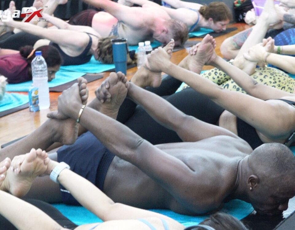 Students of mixed ages lying in the floor series of a heated class with their legs raised together